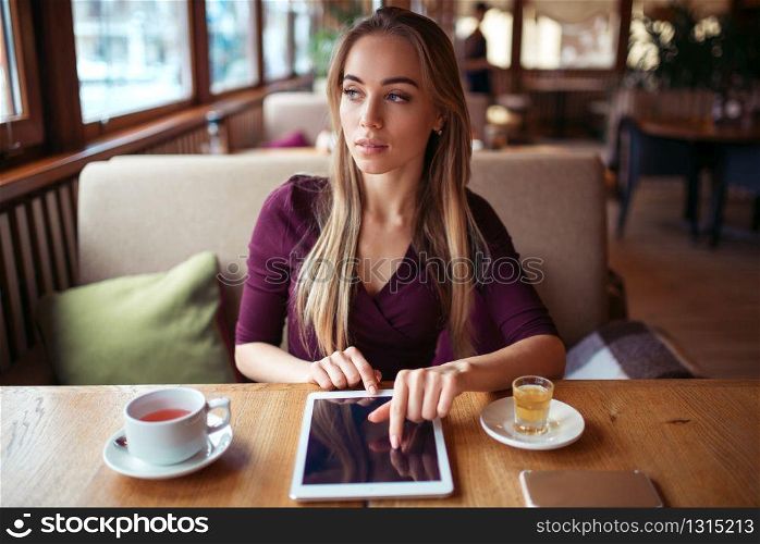 Young woman work on tablet pc using wifi in cafe.