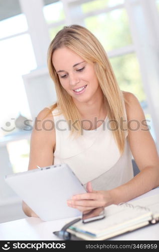 Young woman working at home with electronic tablet