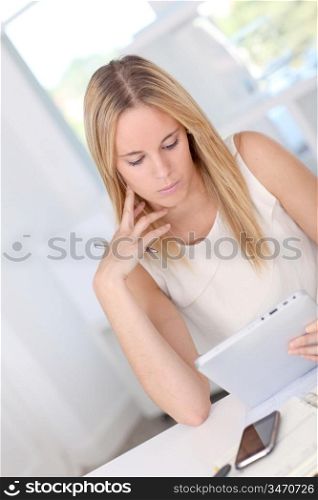 Young woman working at home with electronic tablet