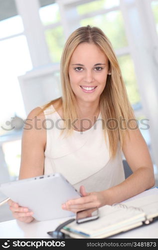 Young woman working at home with electronic tablet