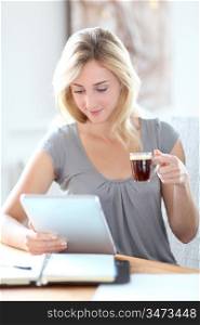 Young woman working at home with touchpad