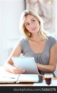 Young woman working at home with touchpad