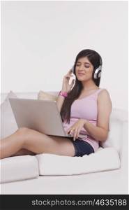 Young woman working on a laptop with headphones on