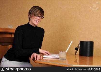 Young woman working on her laptop in a hotel room