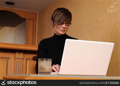 Young woman working on her laptop in a hotel room
