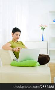 Young woman working on laptop computer at home.