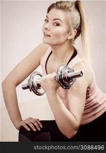Young woman working out at home with heavy dumbbells. Training at home, being fit and healthy.. Woman working out at home with dumbbell
