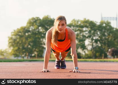 Young woman working out, doing press-ups, outdoors