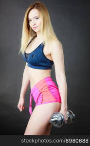 Young woman working out with heavy dumbbells. Training at home, being fit and healthy.. Woman working out with dumbbell