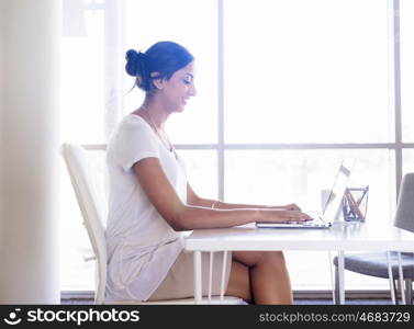 Young woman working with a laptop in office