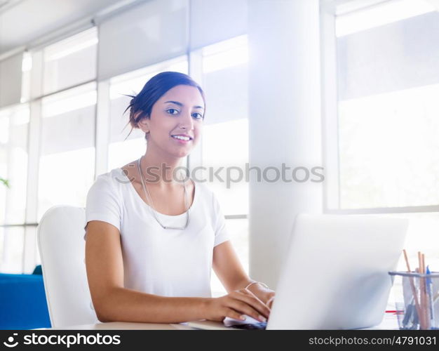 Young woman working with a laptop in office