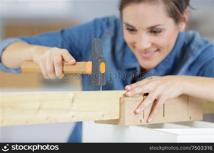 young woman working with hammer