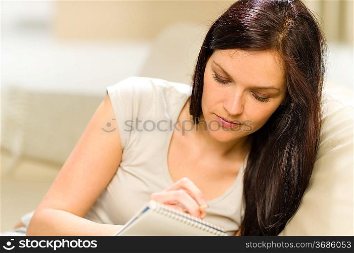 Young woman writing letter to copybook