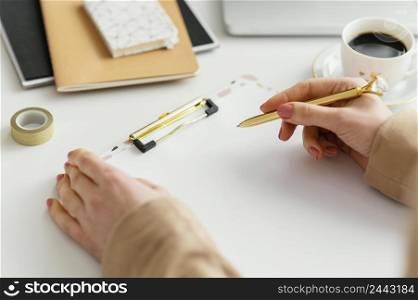 young woman writing notes clipboard