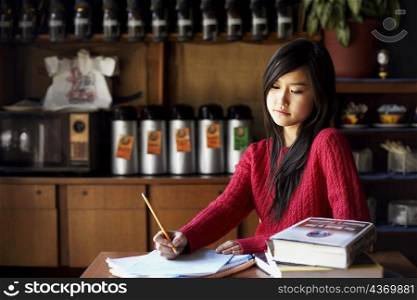 Young woman writing on a sheet of paper