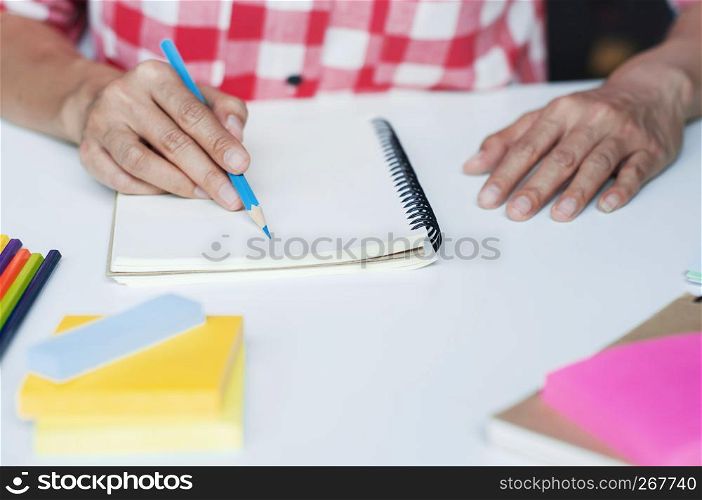 Young woman writing on notebook on the desk