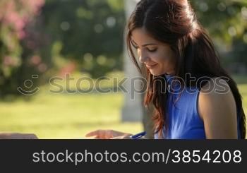 Young women and education, two female friends study for college exam in park. Sequence of medium and wide shots
