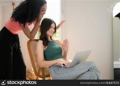 Young women and her friend express their love and concern for each other and using laptop at home, LGBT concept.