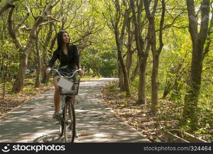 Young women are enjoying riding bicycles in the garden.