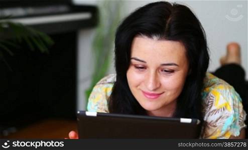 Young women at home using a tablet computer and smiling