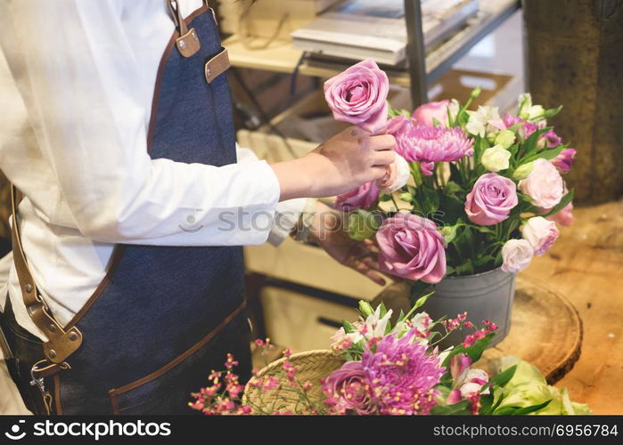 young women business owner florist making bouquet in front of f. young women business owner florist making bouquet in front of flower shop