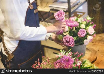 young women business owner florist making bouquet in front of f. young women business owner florist making bouquet in front of flower shop