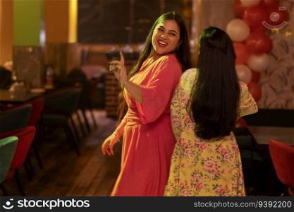 Young women dancing together at restaurant
