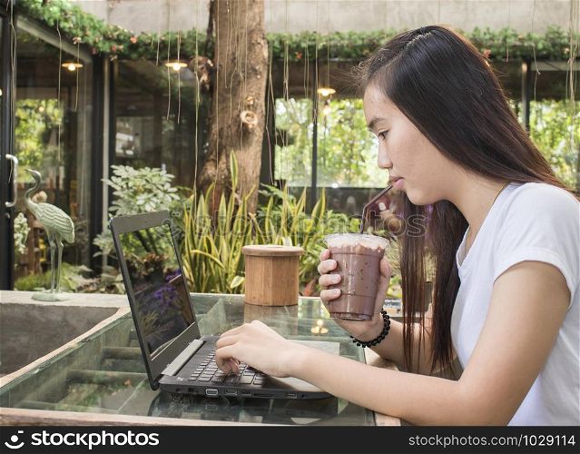 young women drinking coffee and looking laptop