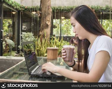 young women drinking coffee and looking laptop