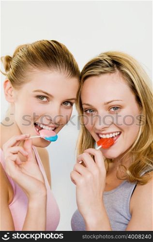 Young women eating lollipops