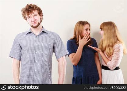 Young women friends talking gossiping about man. Two women whispering sharing secret news.. Two women talking gossiping about man.