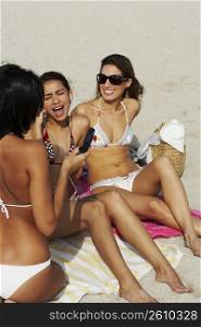 Young women hanging out and sunbathing on beach