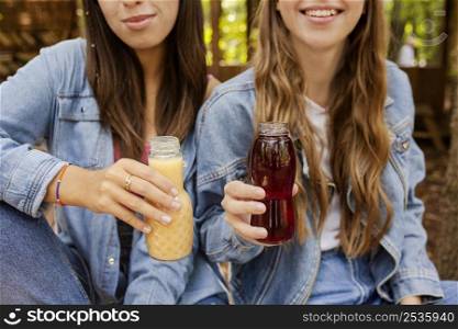 young women holding fresh juice bottles
