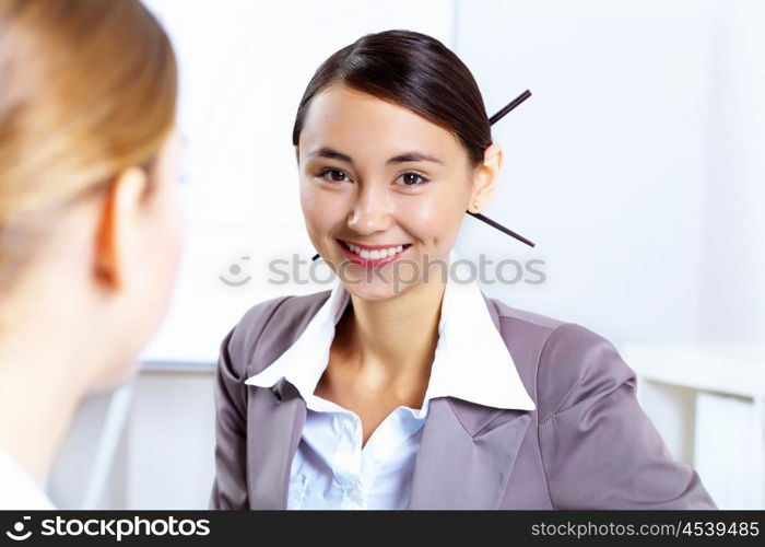 Young women in business wear working in office together