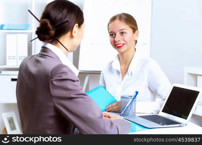 Young women in business wear working in office together