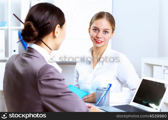 Young women in business wear working in office together