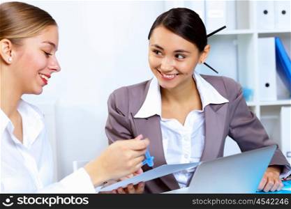Young women in business wear working in office together