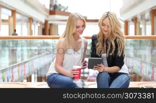 Young women in shopping mall using digital tablet