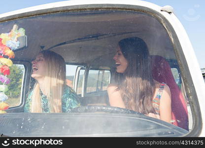 Young women inside campervan laughing