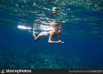 Young women is snorkeling in the tropical water