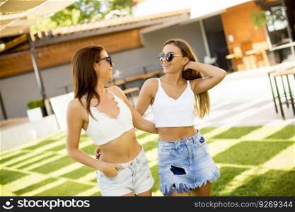 Young women posing in courtyard at hot summer day