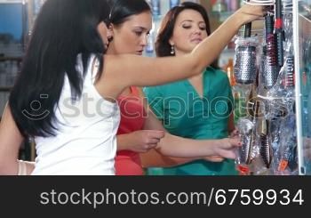 Young Women Shopping in Cosmetics Store, Choosing Hairbrush
