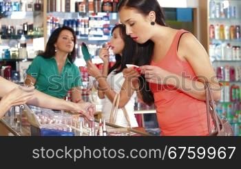 Young Women Shopping in Cosmetics Store, Choosing Lipstick