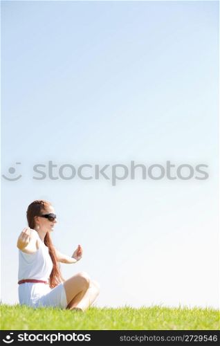 young women sitting on grass and doing meditating