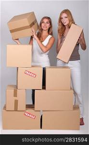 Young women stacking boxes