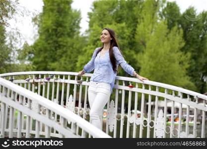 Young women standing on the bridge in a summer park