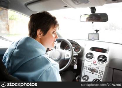 Young Women steering wheel and driving a car in the city using the navigation device
