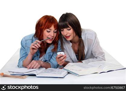 Young women taking a break from studying to read a text message