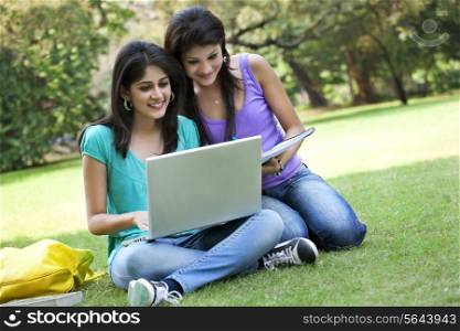 Young women taking notes from laptop