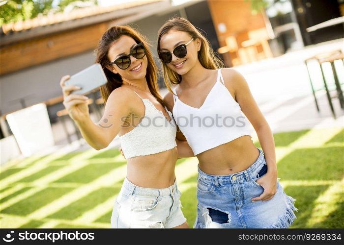 Young women taking selfie outdoor at hot summer day